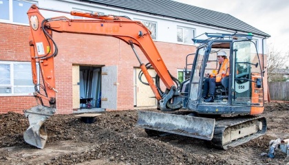 Image of Councillor Dan Swords in a mechanical digger at the Bushey Croft council housing development 