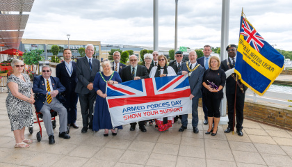 Image of council and Royal British Legion representatives with the Armed Forces Day flag 
