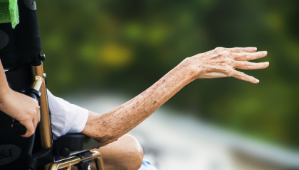 image of women in wheelchair holding out her hand 