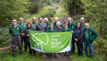 Image of volunteers and council staff at Parndon Wood holding a flag with the text Green Flag Award 2021/22
