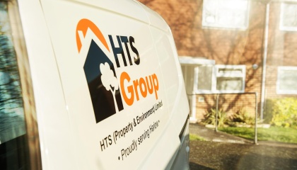 Image of HTS Group logo on the side of a van with houses in the background