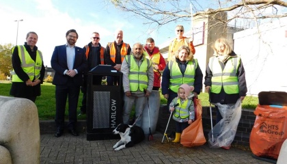 Photo of HTS staff, Councillor Alastair Gunn and members of the Harlow Wombles alongside a litter bin 