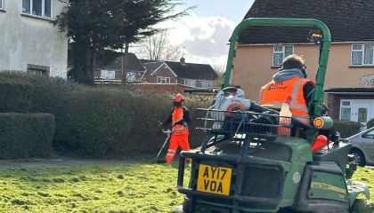 Image of staff cutting grass using a ride on mower and strimmer