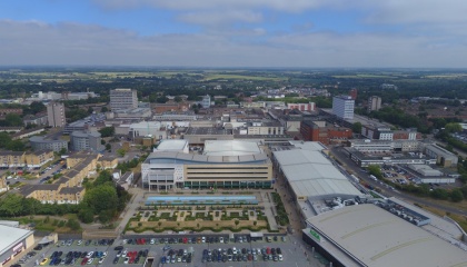 Aerial photo of Harlow town centre, with the Water Gardens car park and Asda in the foreground and Gilston countryside in the background.