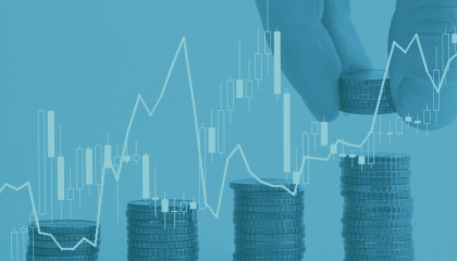 Hand picking up coins behind a graph on an upward curve