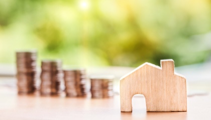 stacks of coins next to a wooden house